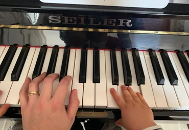Petites mains sur un piano; apprentissage du piano par échange de Vidéos