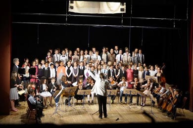Aurélie Rustique qui dirige un choeur et un orchestre d'enfants